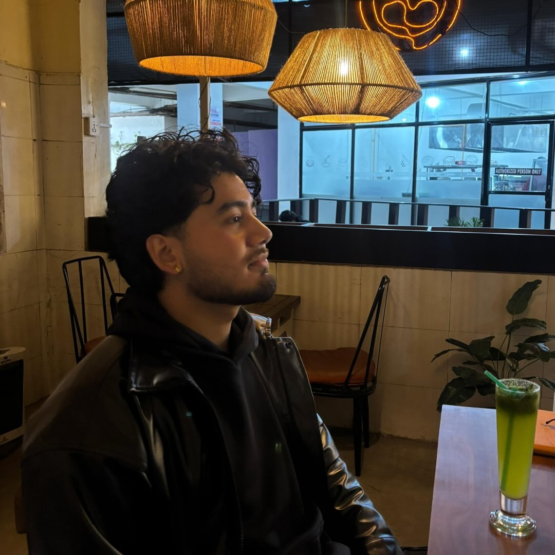 Shreejan Karki in a black jacket at a café